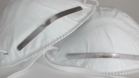 Closeup of white face masks on a white table, slow zoom Stock Footage 130957720