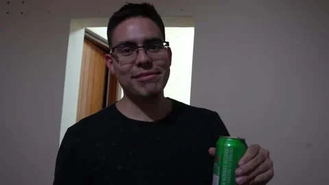Closeup of a white man with glasses talking to the camera with a beer in his 스톡 동영상 170013064