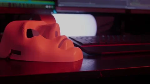 Closeup at the white mask lying on the working place of a programmer, hacker Stock Footage 147667706