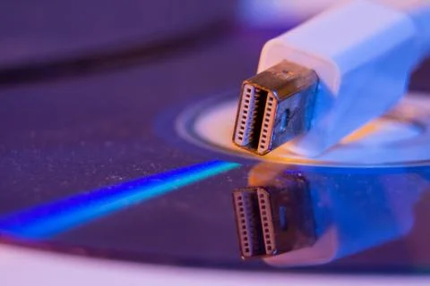 Closeup of white Mini Displayport cable with it's reflection on blank disc Stock Photos