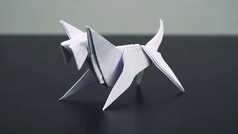Closeup on a white origami dog on a table Stock-Footage 79572247