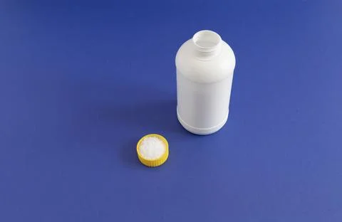 Closeup White Plastic Bottle, Cap Filled With Pipe Cleaner Granules In Hand Stock Photos