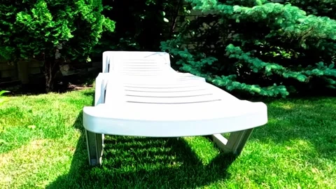 Closeup white plastic deck chair in the garden Stock Footage 311234001