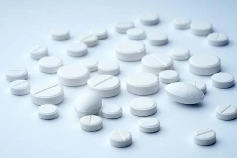 Closeup of white tablets on a white background with texture. Stock Photos