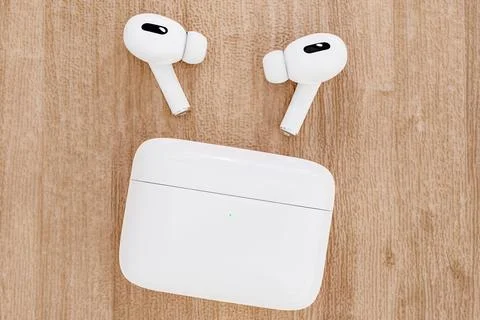 Closeup white TWS true wireless stereo earbuds and case on wooden table bac.. Stock Illustration