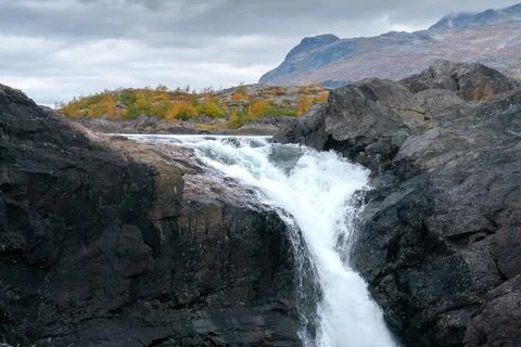 Closeup, wide, low angle shot of mighty Stuor Muorkkegarttje waterfall on Stock Photos