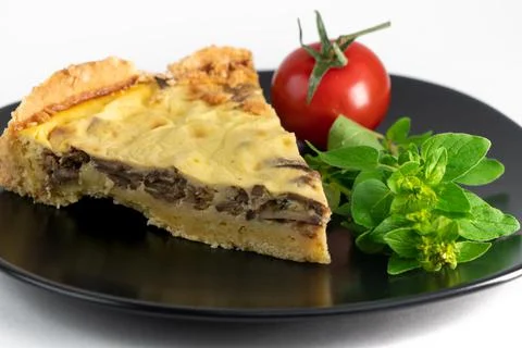 Closeup wide studio shot of a slice of yellow French salty cake, or quiche, with Stock Photos