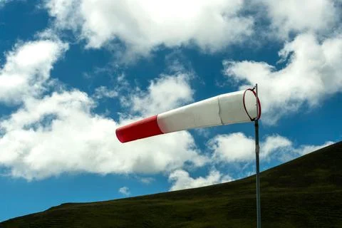 Closeup of a windsock indicator under the blue sky with clouds Stock Photos