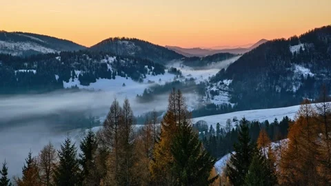 Closeup of a winter valley with misty low clouds flowing over a picturesque Stock-Footage 294579850
