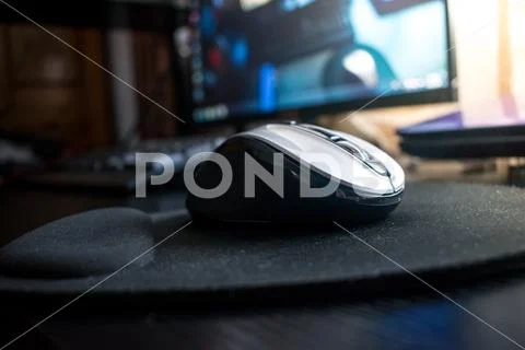 Closeup of Wireless Bluetooth computer mouse on a black desk with mouse pad Stock Photos