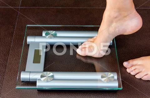 Closeup of woman foot uploading to bathroom scale Stock Photos