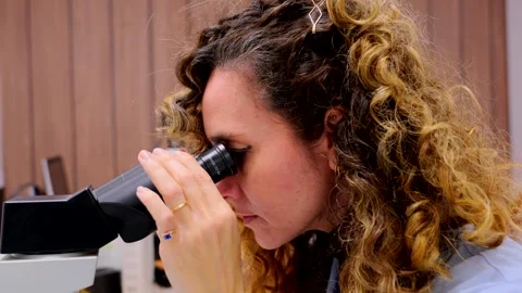 Closeup of woman looking through microscope. Vidéo 261766266
