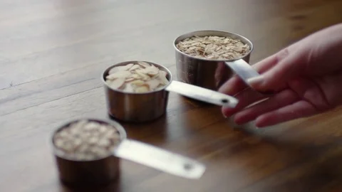 Closeup Of Woman Setting Down 3 Measuring Cups, Preparing Workspace For Baking Stock Footage 82330168
