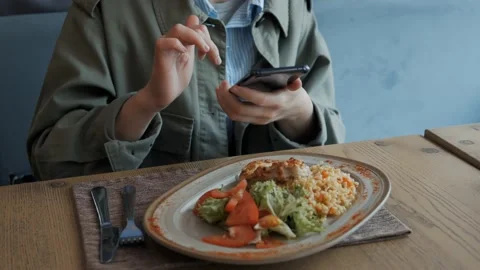 Closeup of a woman using a smartphone camera shoots a vegetable salad on a plate Video stock 131367963