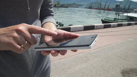 Closeup of woman using smartphone, river in background Stock Footage 76573637