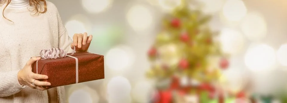 Closeup of woman's hand opens the loop on a present Stock Photos
