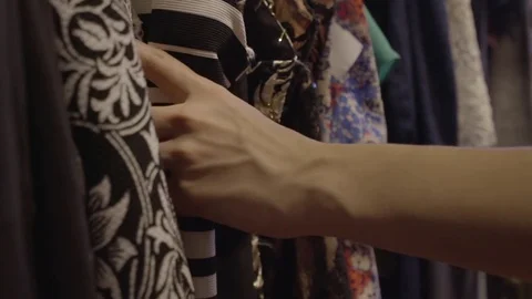 Closeup Of Woman's Hand Sorting Through Garments On Clothing Rack In Boutique Stock Footage 76585798