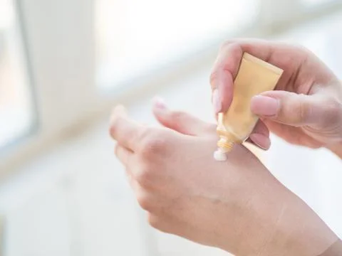 Closeup on woman's hands applying moisturizing hand-cream on Stock Photos