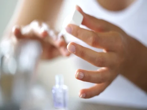 Closeup on woman's hands applying nail polish Stock Footage