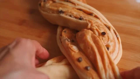 Closeup of woman's hands braiding a babka bread Stock Footage 229705158