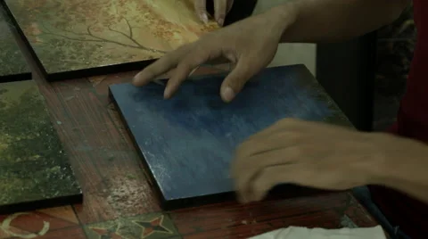 Closeup of a woman's hands creating a piece of wood-panel artwork in Cambodia Stock Footage 48031631