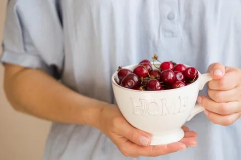 Closeup of woman's hands holding nice white cup with sign Home full of delici Stock Photos