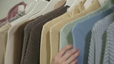 Closeup of woman's hands picking up the clothes in boutique Stock Footage 73903881