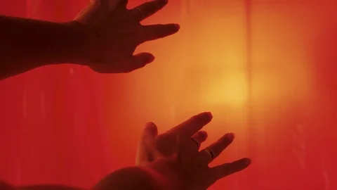 Closeup On Woman's Hands Reaching Toward Glowing Orange Light (Slow Motion) Stock Footage 122486014