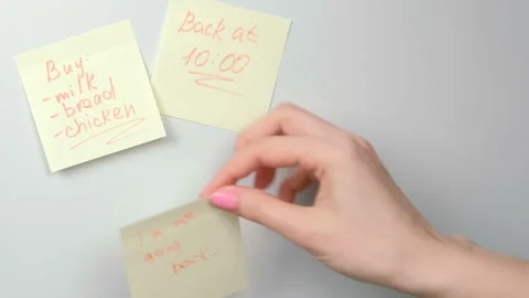 Closeup woman's hands stick yellow sticker paper sheets with words i'm not going Stock Footage 87806395