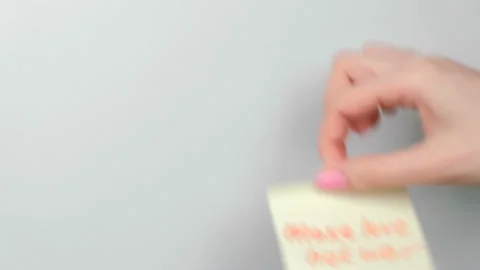 Closeup woman's hands stick yellow sticker paper sheets with words make love not Stock Footage 88307736