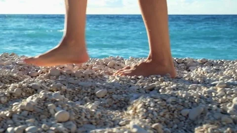 Closeup woman's legs walking on beach at sunset over a sea. Slow motion footage Stock Footage 74276027