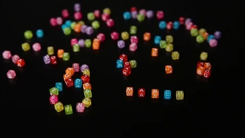 Closeup word "8 MARCH" collected from colorful cubes with letters on black table Stock Footage 100577278