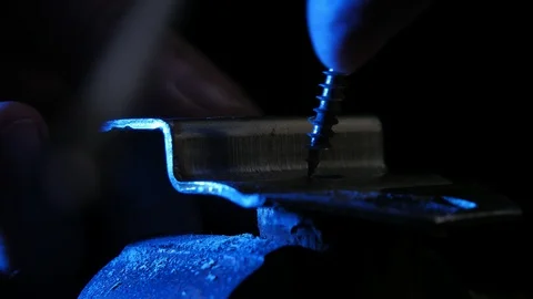 Closeup of worker fixes a metal part twisting the screw into a wood in the Video stock 103962291