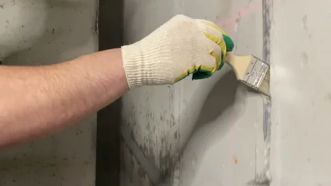 Closeup worker hand putting brush stokes into slit concrete wall electrical Stock Footage 161905604