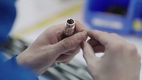 Closeup of worker hands assembling a cable connector in an industrial setting 스톡 동영상 331247384