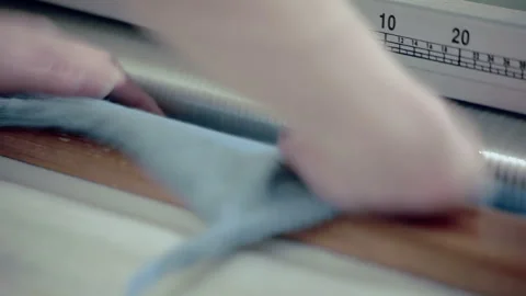 Closeup worker hands feeding fabric roller machine. Textile factory production. Stock Footage 345890127