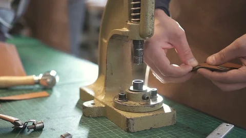 Closeup. Worker insert metal button in belt. working on press with skin. leather Stock Footage 121389927