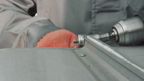 Closeup worker locksmith tightens nut with screwdriver closeup. The master Video stock 143249867