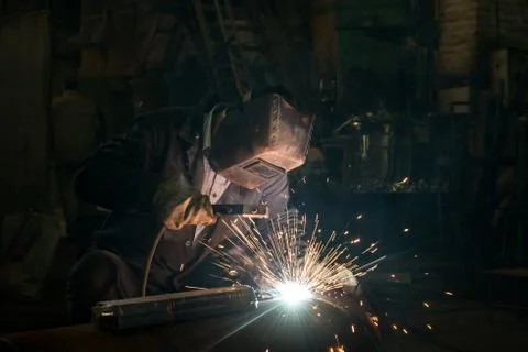Closeup worker in a mask doing the welding in a workshop Stock Photos