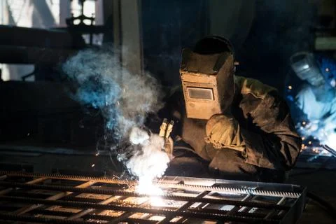 Closeup worker in a mask doing the welding in a workshop Stock Photos