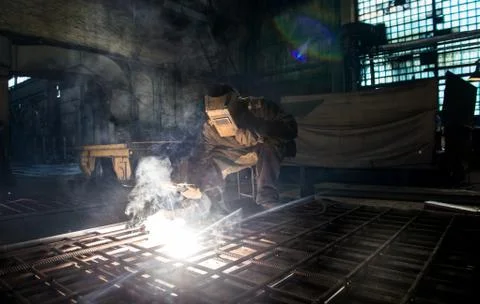 Closeup worker in a mask doing the welding in a workshop Stock Photos