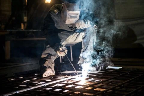 Closeup worker in a mask doing the welding in a workshop Stock Photos
