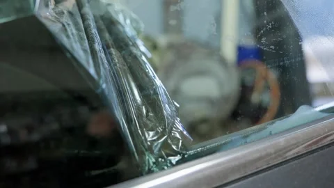 Closeup of a worker in a professional auto service shop carefully peeling off 動画素材 337537893