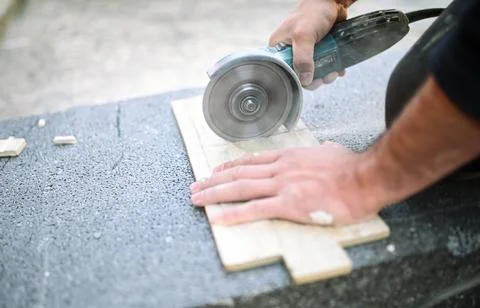 Closeup of a worker use cutting machine to cut a ceramic tile Stock Photos