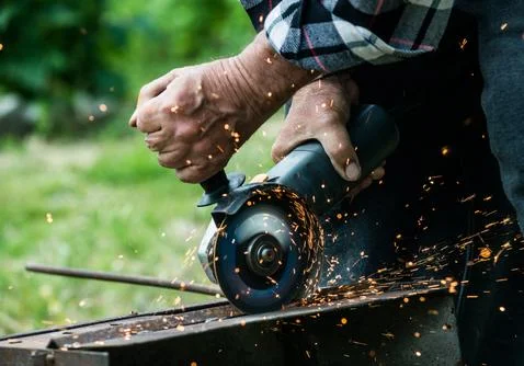 Closeup of worker using a grinder on a metal plate Stock Photos