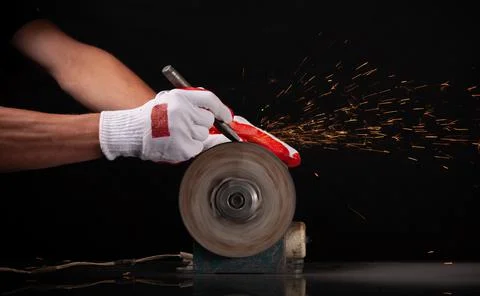 Closeup worker using grinding machine for metal finishing with flash of spark Stock Photos