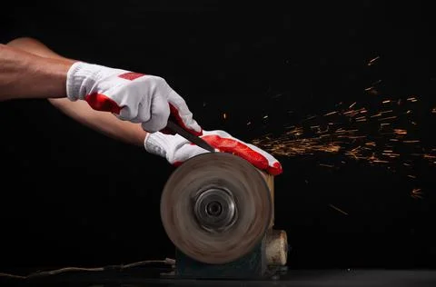 Closeup worker using grinding machine for metal finishing with flash of spark Stock Photos