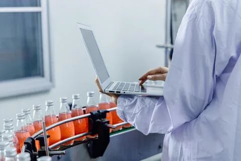 Closeup worker using laptop record products data at production line in food.. Stock Photos