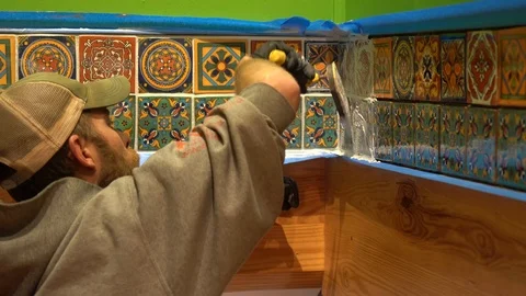 Closeup of worker using spatula float to press grout into spaces between Stock Footage 101434713