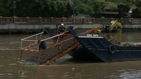 Closeup, workers in trash skimmer boat cleaning up the river Stock Footage 156995016